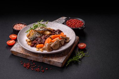 Izgara uskumru fileto, sebzeli, tuzlu ve baharatlı, koyu beton arka planda.