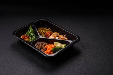 Soya peyniri, buğulanmış sebzeler, tahıllar, tohumlar ve baharatlar ile koyu beton bir arka planda.