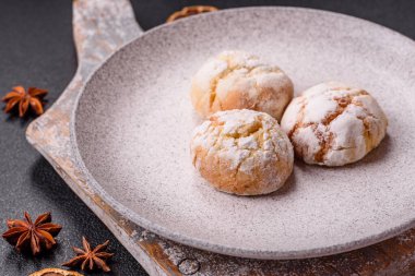 Lezzetli yuvarlak, taze pişmiş limon aromalı kurabiyeler koyu beton arka planda.