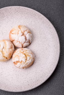 Lezzetli yuvarlak, taze pişmiş limon aromalı kurabiyeler koyu beton arka planda.