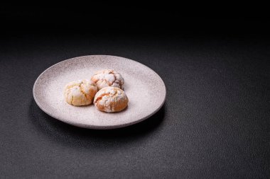 Lezzetli yuvarlak, taze pişmiş limon aromalı kurabiyeler koyu beton arka planda.