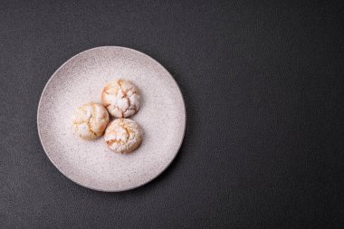 Lezzetli yuvarlak, taze pişmiş limon aromalı kurabiyeler koyu beton arka planda.