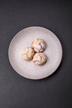 Lezzetli yuvarlak, taze pişmiş limon aromalı kurabiyeler koyu beton arka planda.