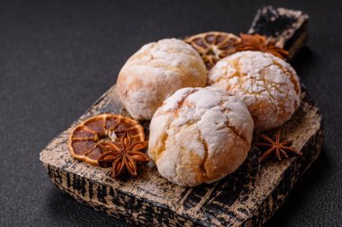 Lezzetli yuvarlak, taze pişmiş limon aromalı kurabiyeler koyu beton arka planda.
