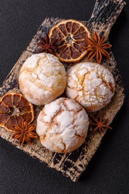 Lezzetli yuvarlak, taze pişmiş limon aromalı kurabiyeler koyu beton arka planda.