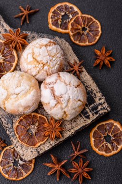 Lezzetli yuvarlak, taze pişmiş limon aromalı kurabiyeler koyu beton arka planda.