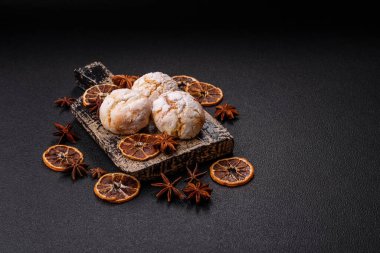 Lezzetli yuvarlak, taze pişmiş limon aromalı kurabiyeler koyu beton arka planda.