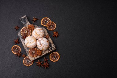 Lezzetli yuvarlak, taze pişmiş limon aromalı kurabiyeler koyu beton arka planda.