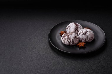 Lezzetli yuvarlak, taze pişmiş çikolatalı kurabiyeler koyu beton arka planda.