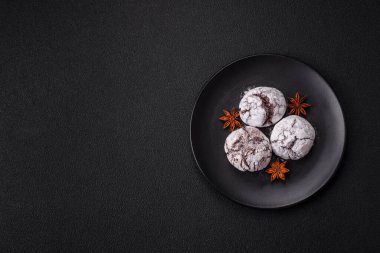 Lezzetli yuvarlak, taze pişmiş çikolatalı kurabiyeler koyu beton arka planda.