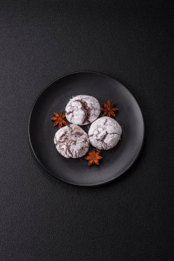 Lezzetli yuvarlak, taze pişmiş çikolatalı kurabiyeler koyu beton arka planda.