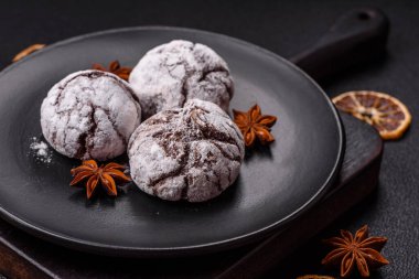 Lezzetli yuvarlak, taze pişmiş çikolatalı kurabiyeler koyu beton arka planda.