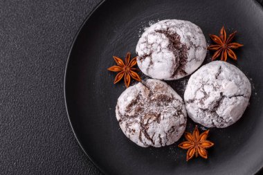 Lezzetli yuvarlak, taze pişmiş çikolatalı kurabiyeler koyu beton arka planda.