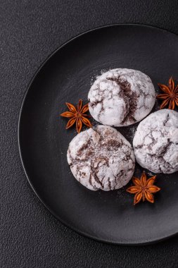 Lezzetli yuvarlak, taze pişmiş çikolatalı kurabiyeler koyu beton arka planda.