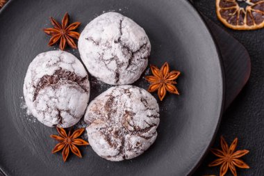 Lezzetli yuvarlak, taze pişmiş çikolatalı kurabiyeler koyu beton arka planda.