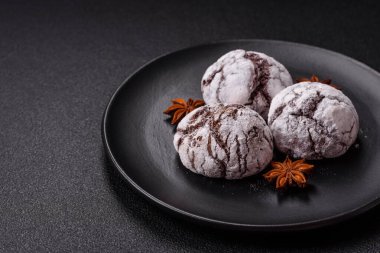 Lezzetli yuvarlak, taze pişmiş çikolatalı kurabiyeler koyu beton arka planda.