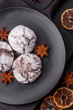 Lezzetli yuvarlak, taze pişmiş çikolatalı kurabiyeler koyu beton arka planda.