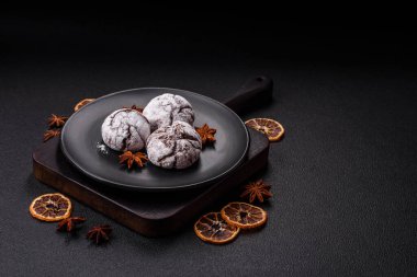 Lezzetli yuvarlak, taze pişmiş çikolatalı kurabiyeler koyu beton arka planda.