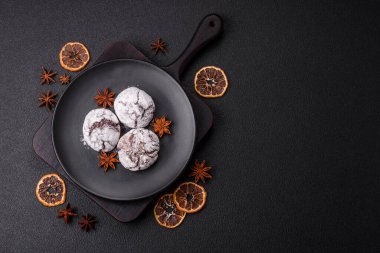 Lezzetli yuvarlak, taze pişmiş çikolatalı kurabiyeler koyu beton arka planda.