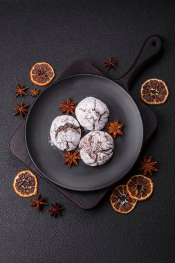 Lezzetli yuvarlak, taze pişmiş çikolatalı kurabiyeler koyu beton arka planda.