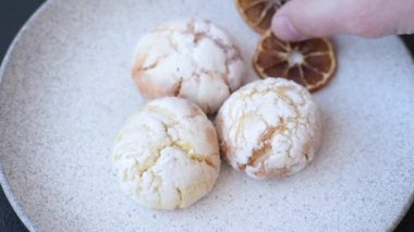 Lezzetli yuvarlak, taze pişmiş limon aromalı kurabiyeler koyu beton arka planda.