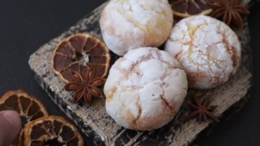 Lezzetli yuvarlak, taze pişmiş limon aromalı kurabiyeler koyu beton arka planda.