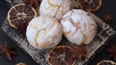 Lezzetli yuvarlak, taze pişmiş limon aromalı kurabiyeler koyu beton arka planda.