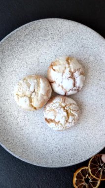 Lezzetli yuvarlak, taze pişmiş limon aromalı kurabiyeler koyu beton arka planda.
