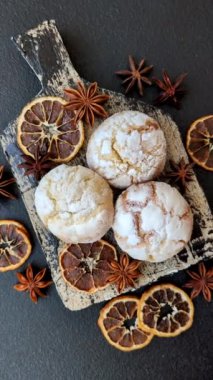 Lezzetli yuvarlak, taze pişmiş limon aromalı kurabiyeler koyu beton arka planda.