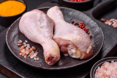 Tuzlu, baharatlı ve çimento kaplı çiğ tavuk bacakları. Evde yemek pişirmek.