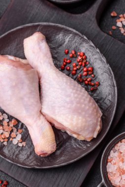 Tuzlu, baharatlı ve çimento kaplı çiğ tavuk bacakları. Evde yemek pişirmek.