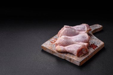 Tuzlu, baharatlı ve çimento kaplı çiğ tavuk bacakları. Evde yemek pişirmek.