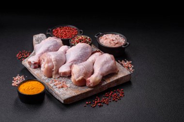 Tuzlu, baharatlı ve çimento kaplı çiğ tavuk bacakları. Evde yemek pişirmek.