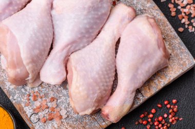 Tuzlu, baharatlı ve çimento kaplı çiğ tavuk bacakları. Evde yemek pişirmek.