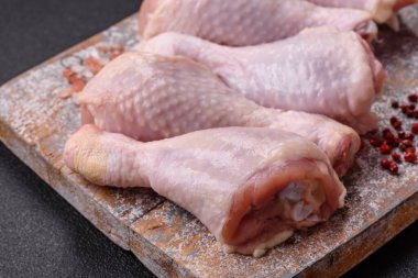 Tuzlu, baharatlı ve çimento kaplı çiğ tavuk bacakları. Evde yemek pişirmek.