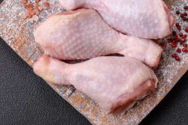 Tuzlu, baharatlı ve çimento kaplı çiğ tavuk bacakları. Evde yemek pişirmek.