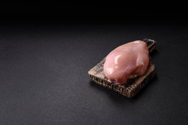 Koyu beton bir masada baharat ve otlarla taze tavuk filetosu. Et yemekleri için hazırlık.