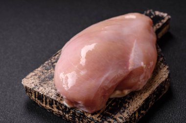 Koyu beton bir masada baharat ve otlarla taze tavuk filetosu. Et yemekleri için hazırlık.