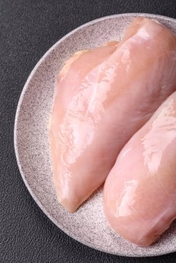 Koyu beton bir masada baharat ve otlarla taze tavuk filetosu. Et yemekleri için hazırlık.