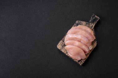 Koyu beton bir masada baharat ve otlarla taze tavuk filetosu. Et yemekleri için hazırlık.