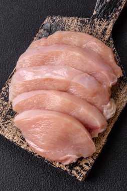 Koyu beton bir masada baharat ve otlarla taze tavuk filetosu. Et yemekleri için hazırlık.