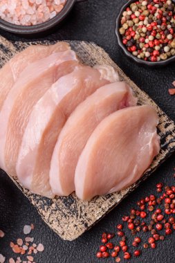 Koyu beton bir masada baharat ve otlarla taze tavuk filetosu. Et yemekleri için hazırlık.