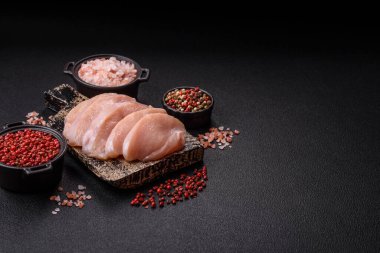 Koyu beton bir masada baharat ve otlarla taze tavuk filetosu. Et yemekleri için hazırlık.