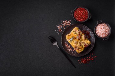 Koyu beton arka planda patates, et, sebze, tuz, baharat ve otlu çoban turtası.