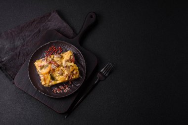 Koyu beton arka planda patates, et, sebze, tuz, baharat ve otlu çoban turtası.