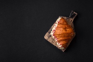 Fıstıklı, ahududulu ve koyu beton kaplamalı çıtır kırmızı kruvasan.