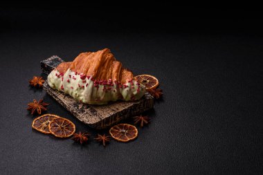 Fıstıklı, ahududulu ve koyu beton kaplamalı çıtır kırmızı kruvasan.