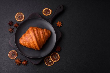 Koyu beton arka planda çikolatalı taze kruvasan.