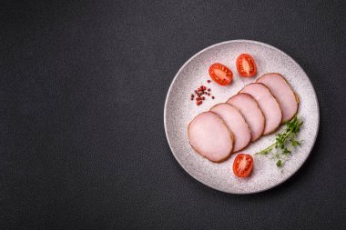 Et, tütsülenmiş, tuz, baharat ve otlarla dilimlenmiş koyu beton arka planda jambon.