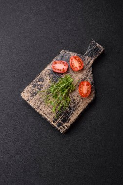 Ahşap kesme tahtasının üzerinde yeşil taze bezelye tohumu koyu beton arka planda